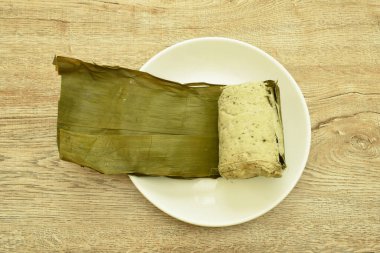 Vietnam usulü domuz püresi ve mantar sosisi. Yeşil muz yaprağıyla sarılıp paketlenmiş. 