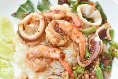 Baharatlı kızarmış karides ve körili kalamar pirinçli çift yiyor.