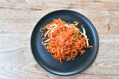 Kızarmış erişte, soya peyniri ve havuç dilimlenmiş sarımsaklı.