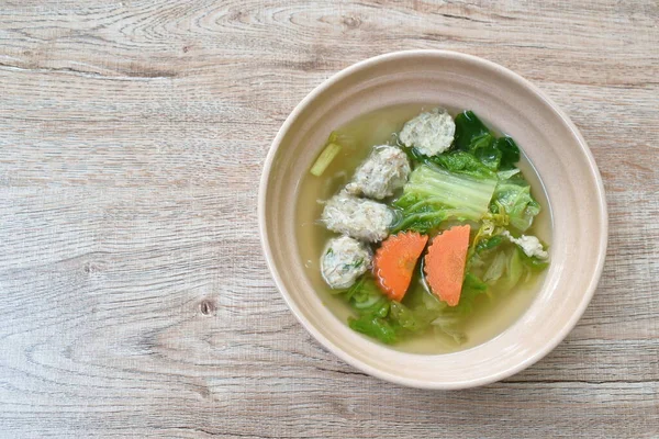 boiled cabbage and carrot with chop pork stuffed glass noodles soup on bowl