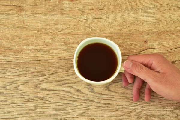 Χέρι Κρατώντας Μαύρο Φλιτζάνι Καφέ Στο Τραπέζι — Φωτογραφία Αρχείου
