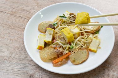  Kızarmış fasulye filizi, dilimlenmiş sarı tofu ve masada domuz pirzolası.