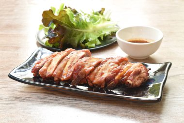 Izgara domuz kemiği dilimi baharatlı acı biber sosu tabakta taze sebze yiyin.