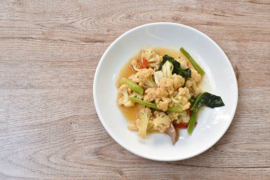 Baharatlı kızarmış karnabahar ve havuç tabağında domuz eti.