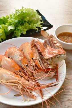 Buharda karides ve tabak üzerinde çiçek yengeci. Taze sebze soslu, baharatlı ve ekşi soslu.