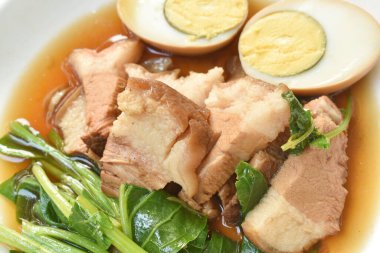 Haşlanmış domuz budu ve Çin lahanalı yumurta tabakta siyah bitki çorbası.