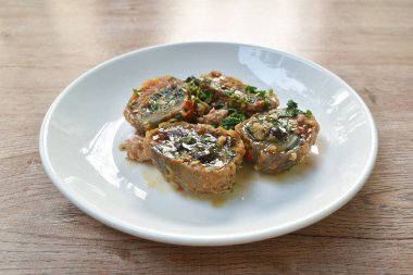 Dilimlenmiş siyah haşlanmış yumurta soslu baharatlı domuz pirzolası ve fesleğen yaprağı.