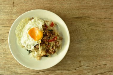 Baharatlı kızarmış domuz pirzolası ve fesleğen yaprağı tabakta pilav üstü yumurta.