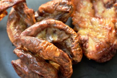 Kızarmış domuz boynu ve içi demirhindi sosuyla kaplı tabakta.