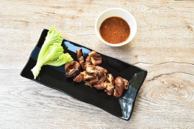 Kızarmış domuz boynu ve içi demirhindi sosuyla kaplı tabakta.