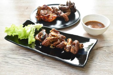 Kızarmış domuz boynu ve içi demirhindi sosuyla kaplı tabakta.