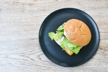  Kızarmış balık peynirli hamburger, mayonez soslu ve marullu.