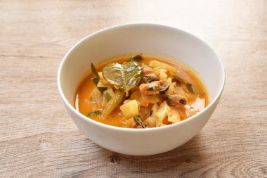 Hindistan cevizi sütlü köri çorbasında ananas ve limon yaprağıyla haşlanmış baharatlı midye.