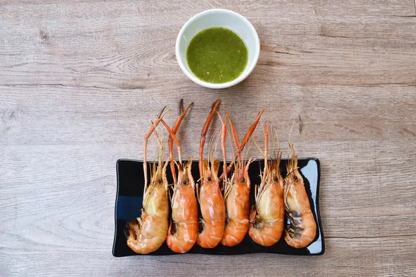 grilled river shrimp arranging on plate dipping spicy sauce