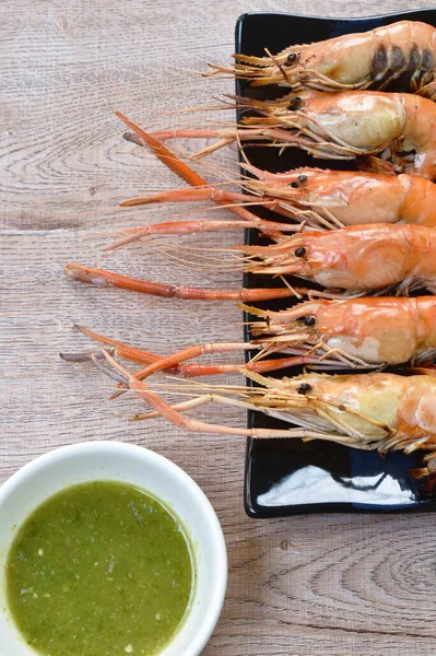 grilled river shrimp arranging on plate dipping spicy sauce