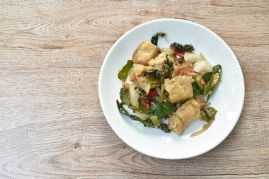  kızartılmış çizgili yılan başı balığı biber ve parmak kökü ile tabakta