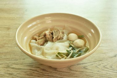  Büyük pirinç erişteleri dilimlenmiş, haşlanmış ve köfte ile mayalanan kasede kahverengi şifalı çorba.