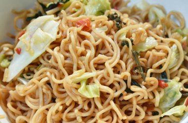  spicy fried instant noodles with cabbage and basil leaf on bowl