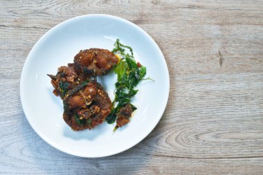  Baharatlı kızarmış yayınbalığı körili ve tabağında fesleğen yaprağı var.