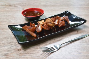  Baharatlı soslu kızarmış domuz kulağı dilimi.