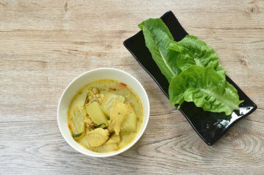  Hindistan cevizi sütlü yeşil köri çorbasında tavuk ve patlıcanla haşlanmış baharatlı kış kavunu.