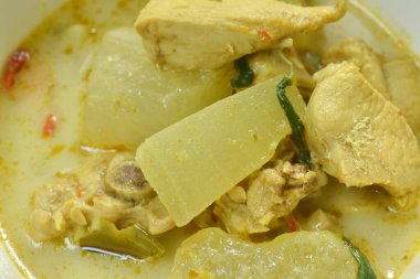   Hindistan cevizi sütlü yeşil köri çorbasında tavuk ve patlıcanla haşlanmış baharatlı kış kavunu.