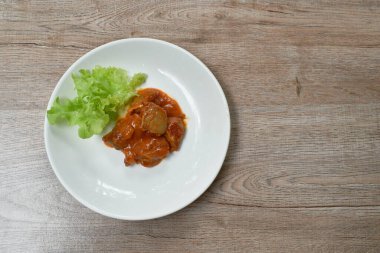  Baharatlı soslu tavuk sosu ve yeşil meşe salatası tabakta.