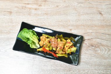  Acı biberli ve limon yapraklı baharatlı kalamar. Tabakta marul.