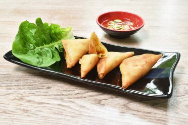  Hamur kızartmalı samosa Hint yemeği tabağa üçgen şeklinde körili dürüm ve tatlı sebze sosuyla doldurulmuş tavuktan yapılır.