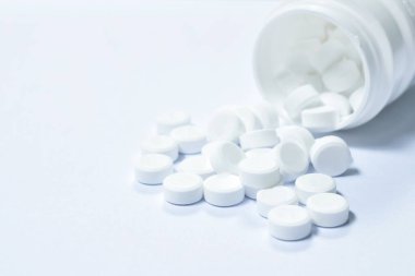  beyaz arka planda şişeden akan tablet ilaç