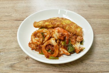  Baharatlı kızarmış karides ve et soslu kalamar körisi tabakta Tayland yumurtalı omlet.