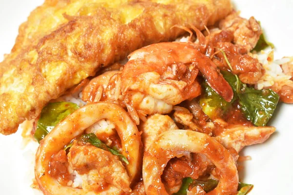  Baharatlı kızarmış karides ve et soslu kalamar körisi tabakta Tayland yumurtalı omlet.