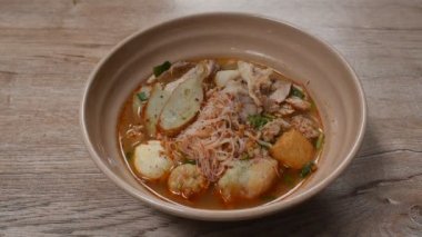 Baharatlı vermicelli şehriye dilimlenmiş domuz eti ve yemek çubuklarıyla kase üzerinde Tom yum çorbası.