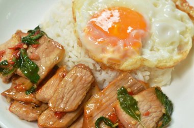  Baharatlı kızarmış domuz eti, acı biber ve fesleğen yaprağı soslu yumurta.