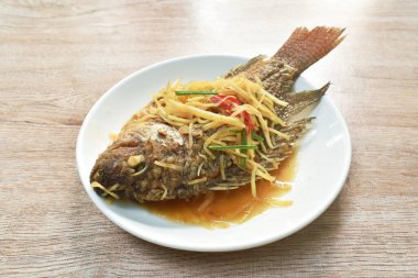  Kızarmış Nil Tilapia ya da mango balığı soslu soya sosu ve tabakta taze soğan.