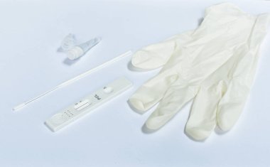  COVID-19 veya beyaz arkaplanda eldiven olan koronavirüsü kontrol etmek için antijen test kiti