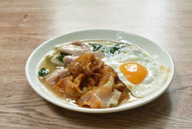  Kızarmış pirinç eriştesi, soya sosu mayalanmış domuz eti ve soslu Çin lahanası tabakta yumurta.