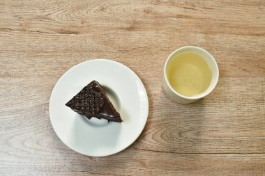  Çikolatalı siyah orman keki ve masada sıcak çay fincanı.