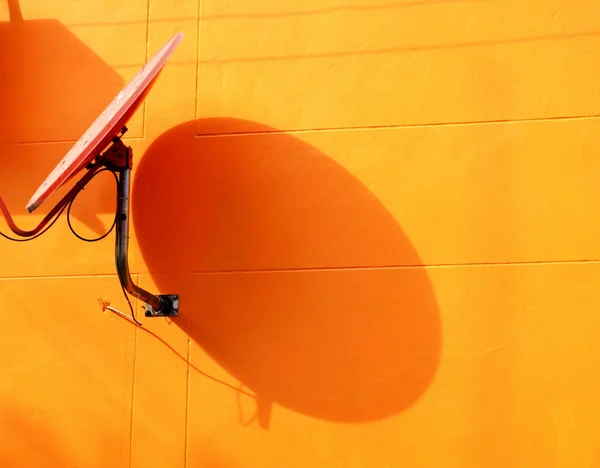 주황색 벽에 위성 접시 — 스톡 사진
