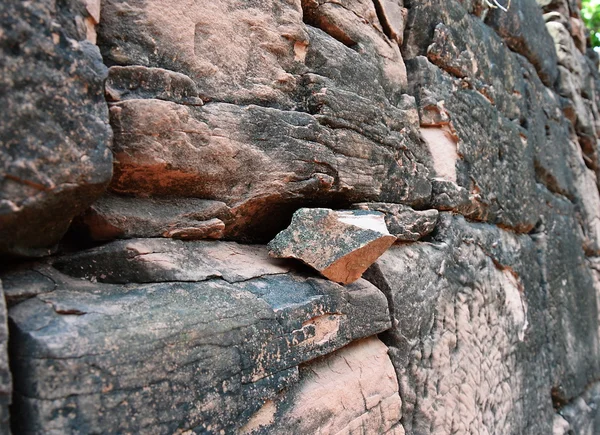 Pezzo di triangolo antica roccia sulla parete — Foto Stock