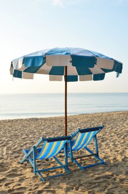 mavi ve beyaz şemsiye ile plaj tuval yataklar