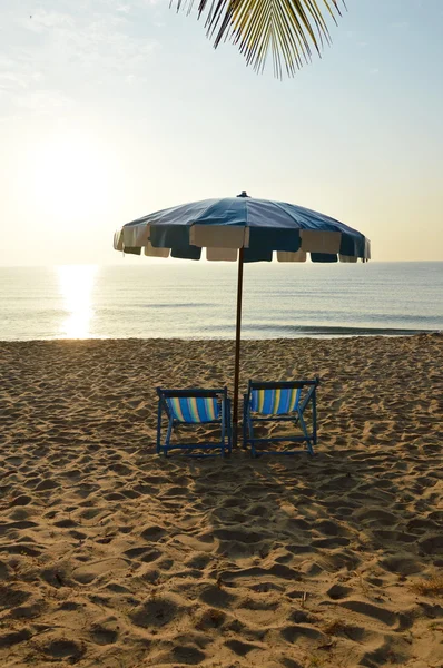 Lits en toile de plage avec parasol bleu et blanc — Photo