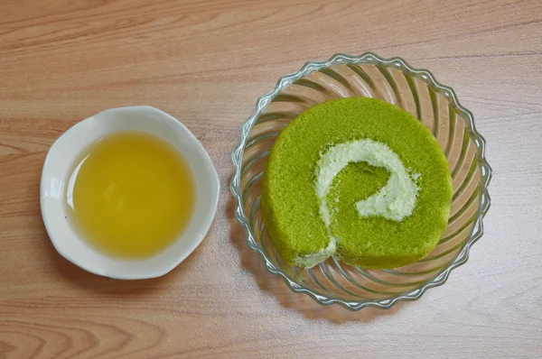 Teetasse und grüne Teekuchenrolle — Stockfoto
