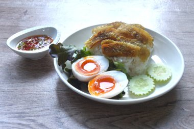 Yağda kızartılmış gourami balığı sade pilav, kaynamış yumurta ve baharatlı tatlı balık soslu taze sebze. 