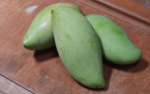 Grüne Mango auf dem Holz — Stockfoto