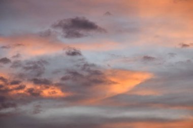 Bulutlar, turuncu alacakaranlık üzerine yayılıyor. Akşam gökyüzü.  