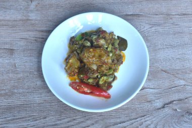 Baharatlı domuz kemiği ve tabakta körili fasulye.