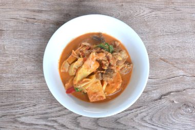 Hindistan cevizi sütlü köri çorbasının üzerine sığır eti soslu taze bambu filizi.