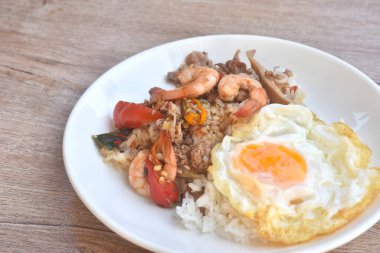 Baharatlı domuz pirzolası ve karidesli kalamar parmak kökünden pirinç kabuğu tabakta yumurta.