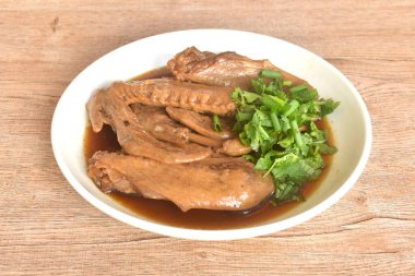 Kaynamış ördek kanadı güveci. Kahverengi soya çorbası. Üstüne de maydanoz ve taze soğan.